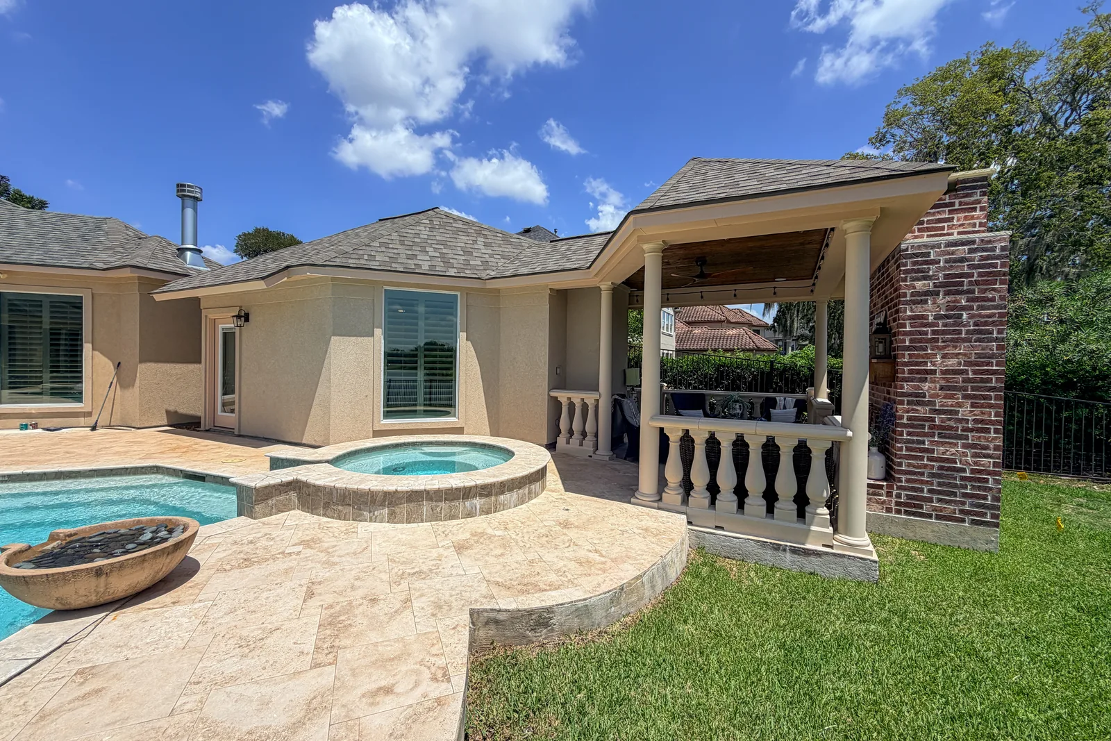 Covered patio addition with brick columns and a matching roofline blending into the existing home exterior in Manvel, TX