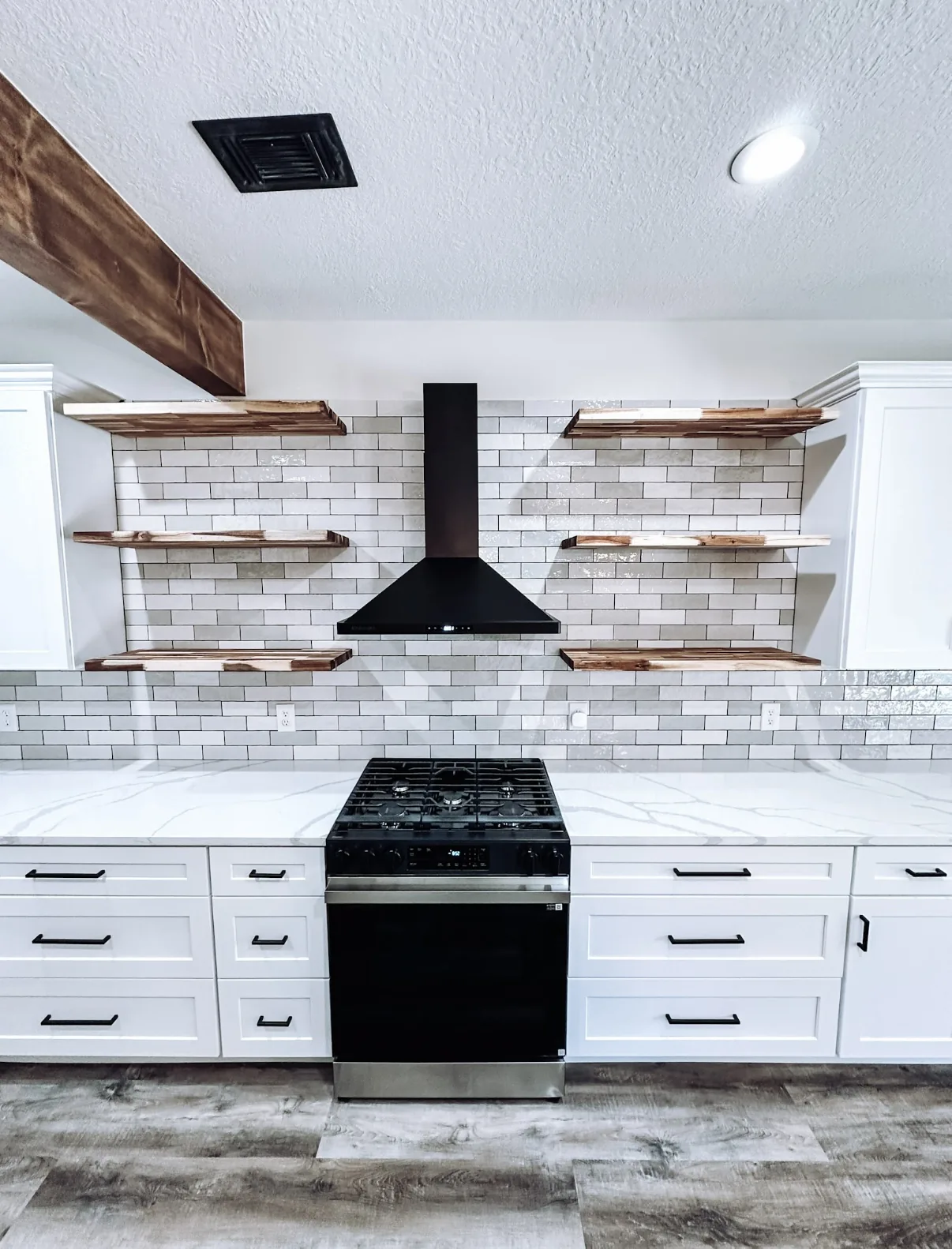 Remodeled kitchen with floating shelves and gas range by Texan Home Additions in Manvel, TX