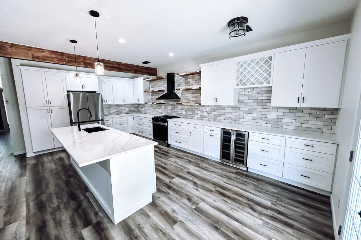 Remodeled kitchen with white shaker cabinets, subway tile backsplash and a quartz island in Pearland, TX
